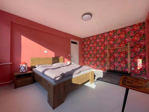 - une chambre avec un lit et un mur rouge dans l'établissement Amazing penthouse, à Sarajevo