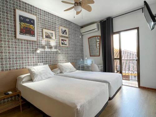 a bedroom with two beds and a window at Beatriz Charming Hostal in Torremolinos