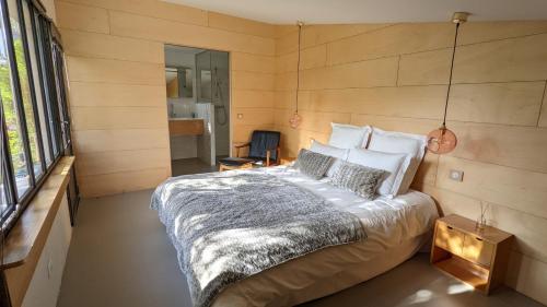 um quarto com uma cama grande e uma parede de madeira em Villa de charme avec Jardin dans Saint Martin Intramuros em Saint-Martin-de-Ré