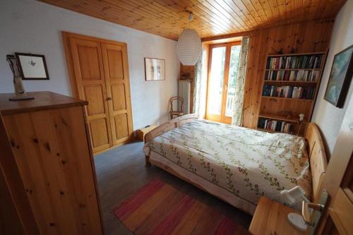 1 dormitorio con cama y estante para libros en Grosszügige Ferienwohnung für 1-6 Gäste, en Evolène
