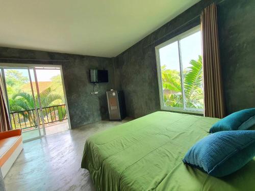 ein Schlafzimmer mit einem großen Bett und einem großen Fenster in der Unterkunft Bansuanrimnam Pakchong Resort in Pak Chong