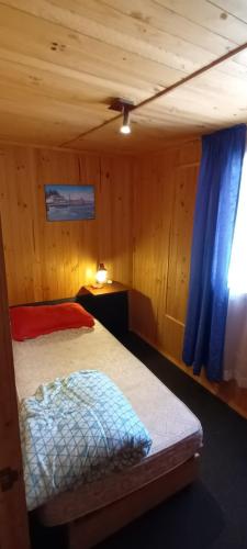 a bedroom with a bed and a blue curtain at Cabaña Horcon in Puchuncaví