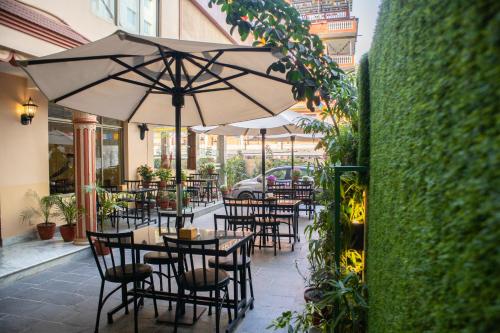a restaurant with tables and chairs with an umbrella at Magnificent Hotel in Kathmandu