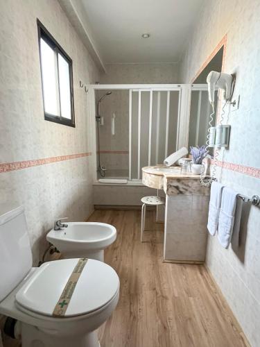 a bathroom with a toilet and a sink at Beatriz Charming Hostal in Torremolinos