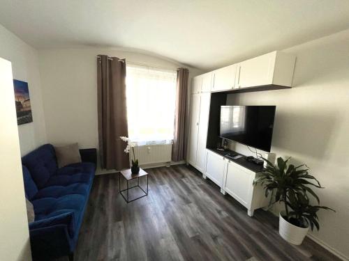 ein Wohnzimmer mit einem blauen Sofa und einem Flachbild-TV in der Unterkunft 40 qm Appartment Parkplatz, Balkon,Netflix, Prime in Chemnitz