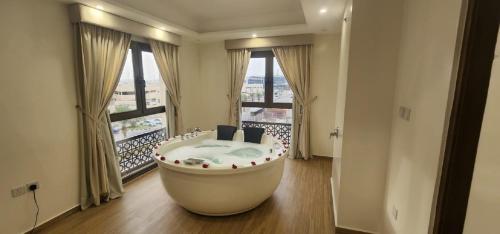a bath tub in a room with a large window at فندق جولدن ايليت Golden Elite Hotel in Al Khobar
