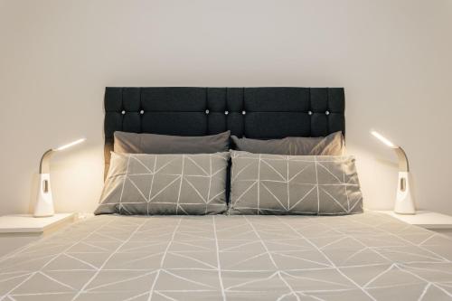 łóżko z czarnym zagłówkiem i 2 poduszkami w obiekcie Modern Peaceful Flat in Town w Bournemouth