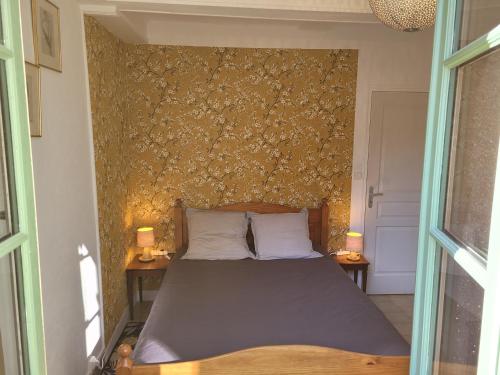 a bedroom with a bed with two lamps on two tables at La Cour du Château in La Charité-sur-Loire