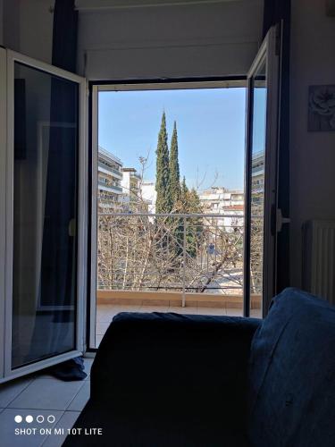 a living room with a large sliding glass door at Gk Suites-Constantin view , auto check-in 24h in Larisa
