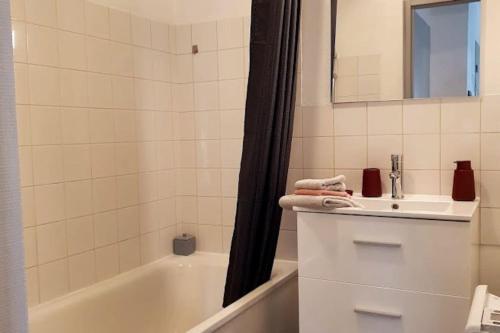 La salle de bains blanche est pourvue d'un lavabo et d'une baignoire. dans l'établissement Dolce vita en centre ville, à Niort