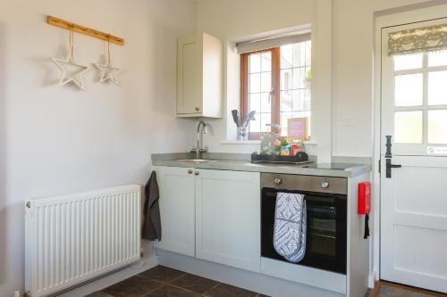 uma cozinha com um lavatório e um fogão forno superior em Wick House em Taunton