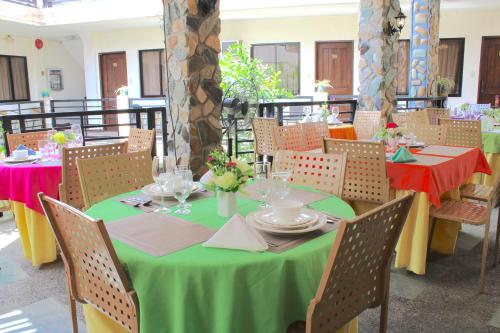 a dining room with a green table and chairs at Balaibinda Lodge in Coron