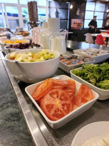 a buffet with bowls of tomatoes and other foods at ibis Antofagasta in Antofagasta