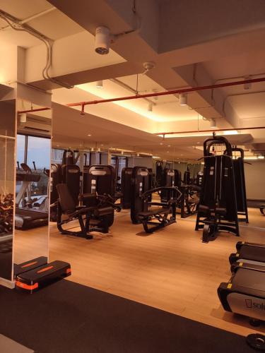 a gym with lots of equipment in a room at DeAr UC Apartment in Surabaya