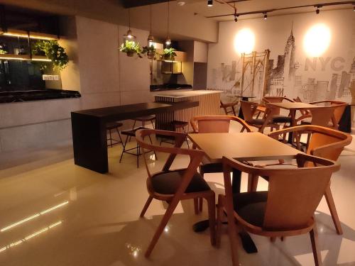 DeAr UC Apartment في سورابايا: مطعم فيه طاولات وكراسي في الغرفة
