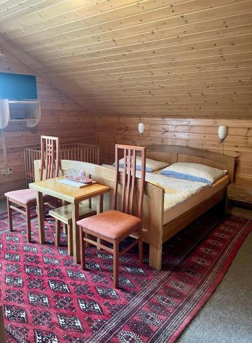 a bedroom with a bed and two chairs and a table at Pension Grizzly in Ludvíkov