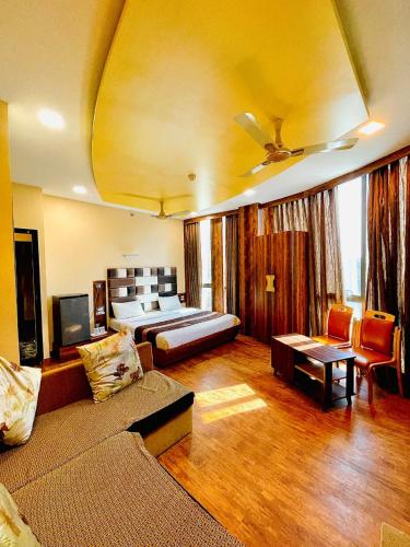 ein Wohnzimmer mit einem Bett und einem Sofa in der Unterkunft AVIRAHI HOTEL in Mumbai