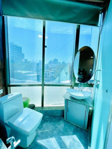 a bathroom with a toilet and a sink and a mirror at AVIRAHI HOTEL in Mumbai