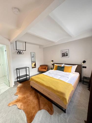 1 dormitorio con 1 cama grande con manta amarilla en Appartement Auhagen - Küche, Badewanne, Regendusche, Netflix, en Auhagen