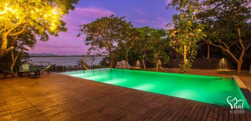 a green swimming pool on a wooden deck at Yaal by Aryaana - Villa in Yala in Tissamaharama