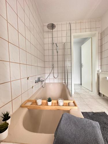 un baño con una bañera con dos plantas. en Appartement Auhagen - Küche, Badewanne, Regendusche, Netflix, en Auhagen