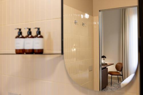 a bathroom with a mirror and some bottles on a shelf at Cà Bèla - Pergolesi in Milan