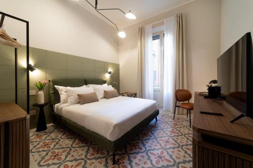 um quarto de hotel com uma cama e uma televisão em Cà Bèla - Pergolesi em Milão