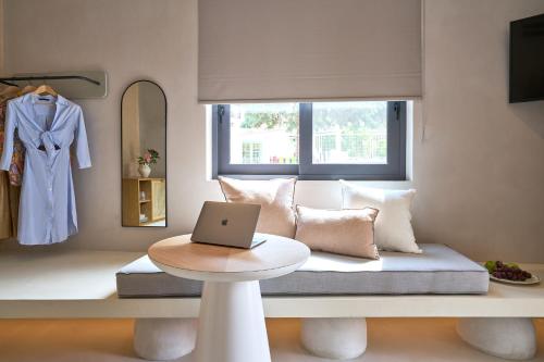 a room with a couch with a laptop on a table at Skiathos Senses in Skiathos Town