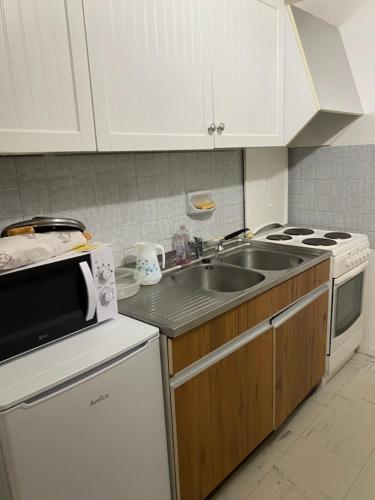 a kitchen with a sink and a stove at bel appartement du sancy in Le Mont-Dore