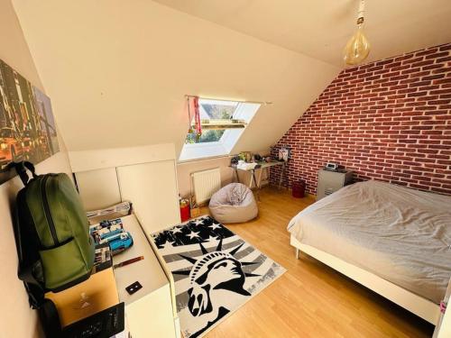 - une chambre avec un lit et un mur en briques dans l'établissement Maison au Mans, 6 pièces, 8 personnes, au Mans