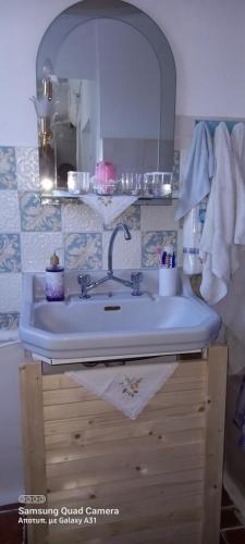 ein Bad mit einem Waschbecken und einem Spiegel in der Unterkunft Elizas house in Nea Makri