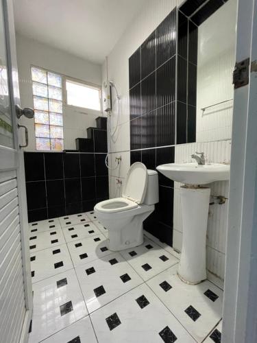 a bathroom with a toilet and a sink at ควีนเพลส สระบุรี Queenplace Saraburi in Sara Buri