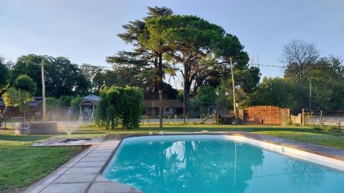 een zwembad in een tuin met een huis bij Casa de campo en Tomás Jofré in Tomás Jofré