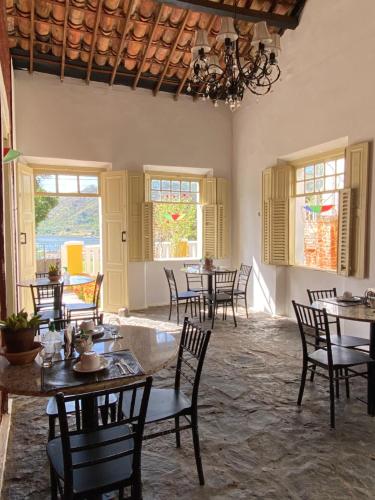 a dining room with tables and chairs and windows at O Canto Pousada in Piranhas