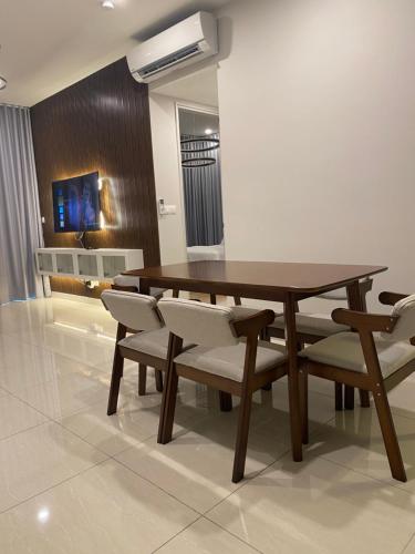 jadalnia z drewnianym stołem i krzesłami w obiekcie Datum Jelatek Sky Residence KLCC SkyRing Linked to LRT and Mall w Kuala Lumpur