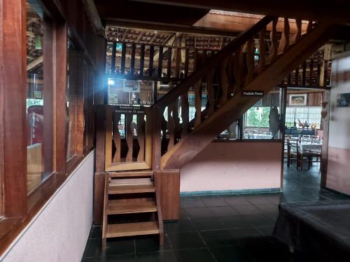 a wooden staircase in a room with a table at VELINN Hotel Fazenda Estrela da Serra in Santo Antônio do Pinhal