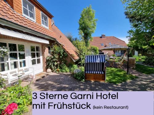 une maison dotée d'une cour avec un banc devant elle dans l'établissement Hotel Garni Friesenhuus, à Greetsiel