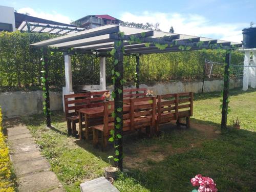 a pergola with two benches and a table under it at Villa San Gabriel in Socorro
