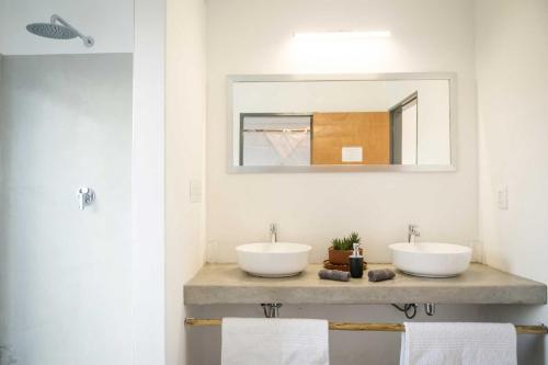 Baño con 2 lavabos y espejo en Kruger Cliffs Lodge, en Hoedspruit
