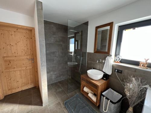 a bathroom with a shower and a sink and a mirror at Bergchalet Stolzalpe in Stolzalpe