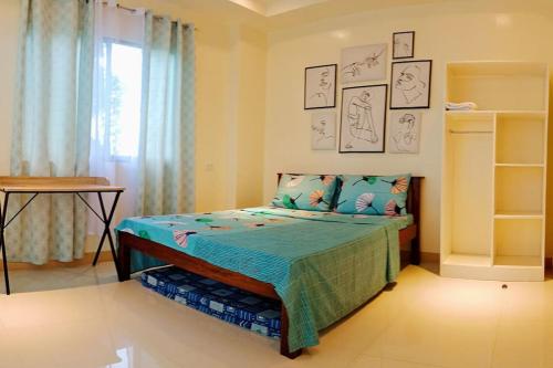 1 dormitorio con 1 cama con edredón azul en DJL House Homestay -Bantayan Island, en Patao
