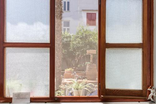 uma janela aberta com vista para um jardim em B&B OTIUM em Pompeia