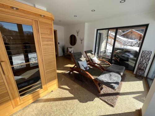 a living room with a chair and a large window at Bergchalet Stolzalpe in Stolzalpe