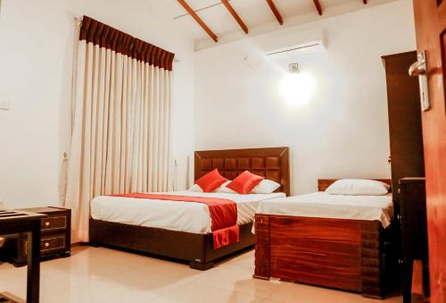 a bedroom with two beds and a window at Seyru in Kandy