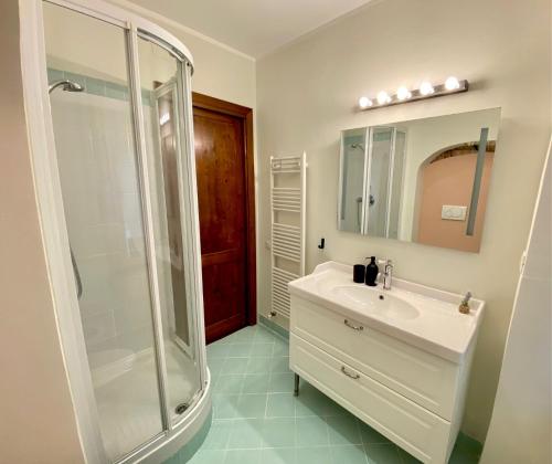 热那亚Tito's place的一间白色浴室，配有淋浴和洗手池。