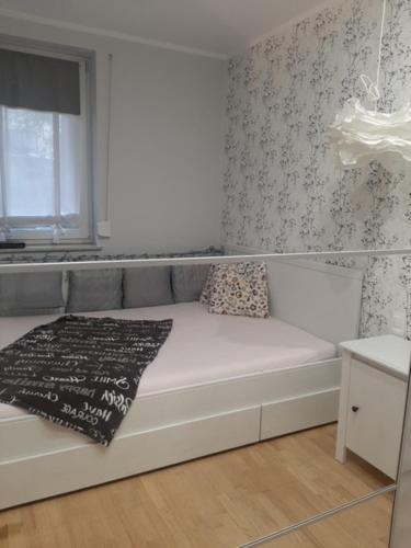 uma cama branca com um cobertor num quarto em Apartament Nad Zatoką Puck em Puck