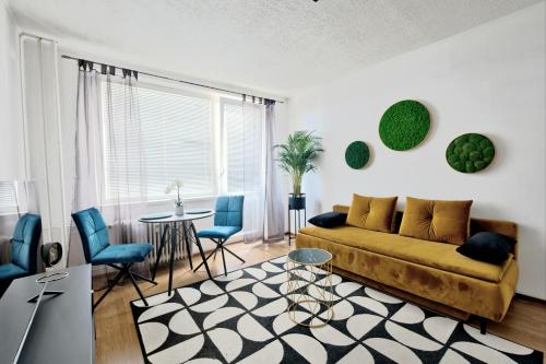 a living room with a couch and a table and chairs at Moderny byt, 300 m do centra mesta in Košice