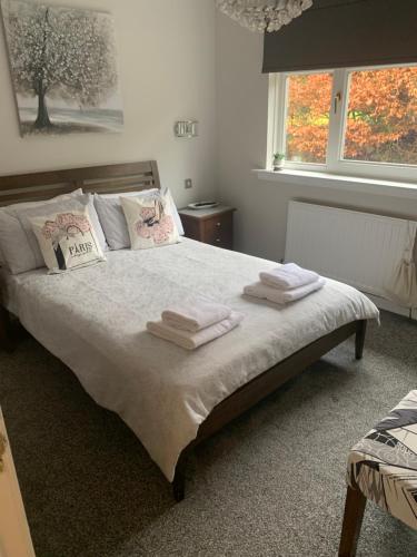 een slaapkamer met een bed met handdoeken erop bij Southfork Villa Guesthouse in Callander