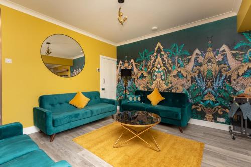 a living room with blue couches and a mirror at OnSiteStays - Stylish 4 BR House with Beautiful Outdoor Space, Wi-Fi & Smart TVs in Dartford