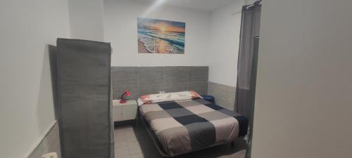 バレンシアにあるCarrer de l'Arquitecte Alfaro 27 bajo derechaのベッドルーム1室(ベッド1台付)が備わります。壁には絵画が飾られています。